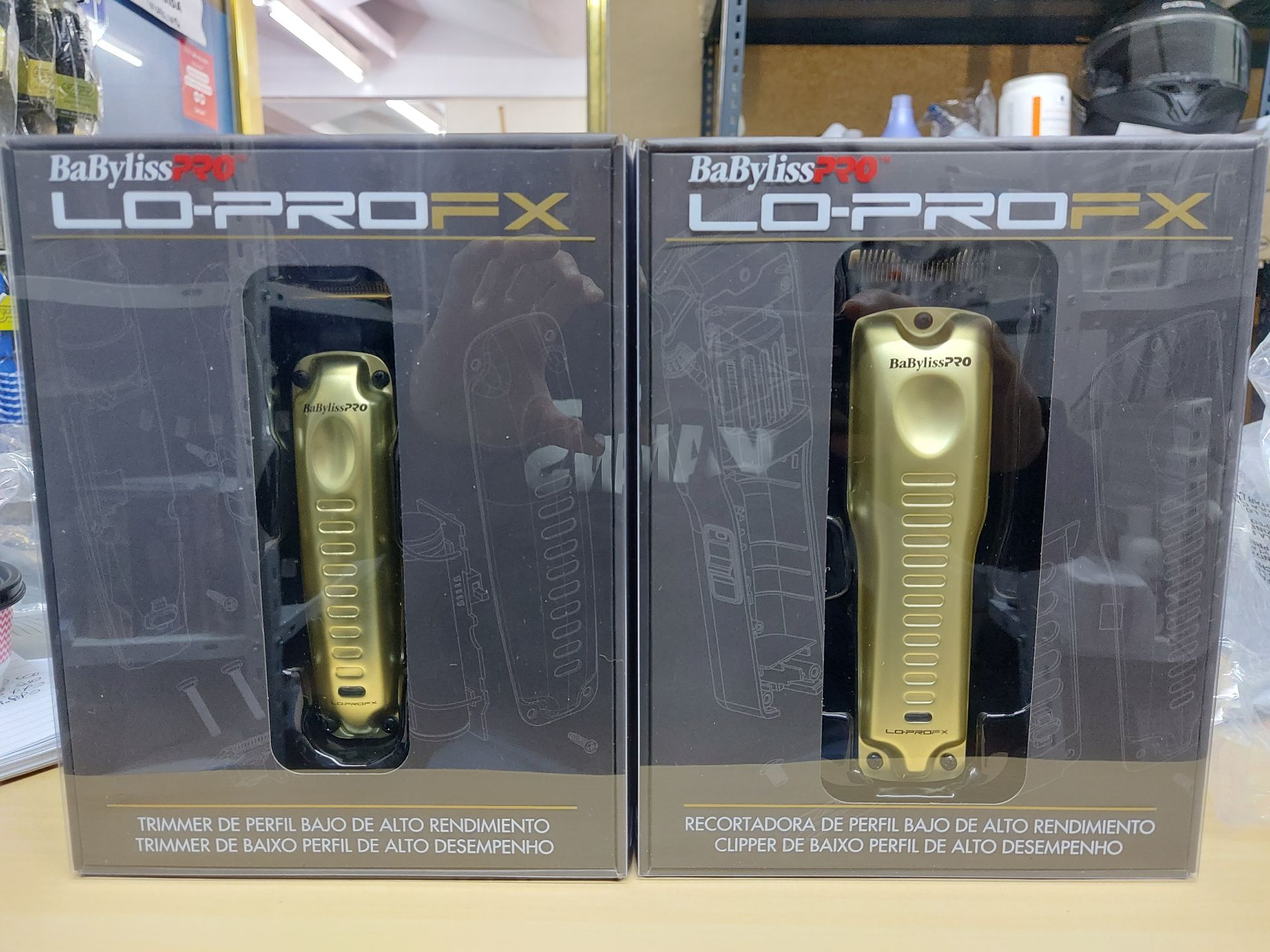 Dos cortadoras de pelo BaByliss Pro Lo-PRO FX doradas en sus cajas, expuestas una al lado de la otra sobre una superficie.