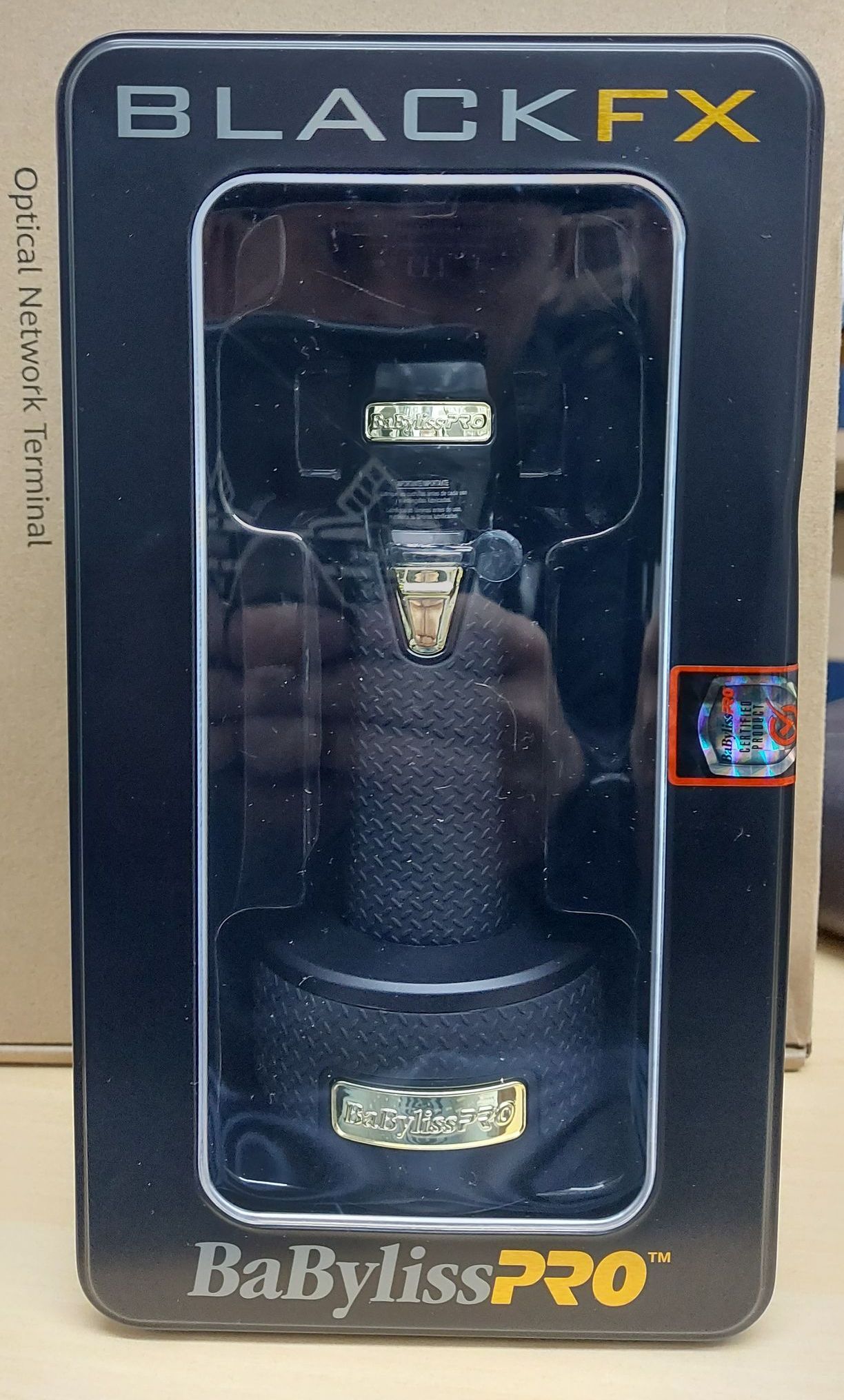 Recortadora de pelo BabylissPRO negra en su embalaje. Diseño en negro y dorado.