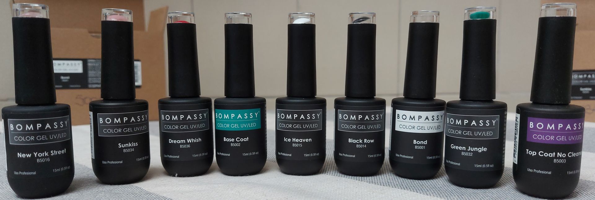Primer plano de 8 botellas de esmalte de uñas negro con esmalte de uñas de diferentes colores visibles.