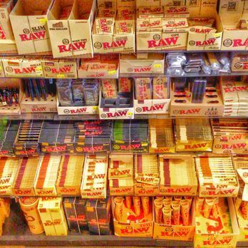 A store shelf filled with boxes of raw cigarettes.