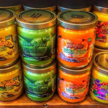 A bunch of jars of candles are stacked on top of each other on a shelf.