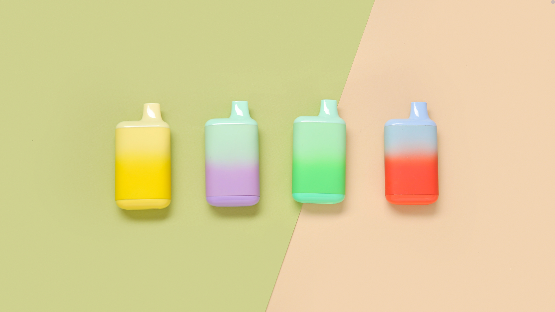 A set of pastel-colored disposable vapes with gradient designs, including yellow, purple, green, and