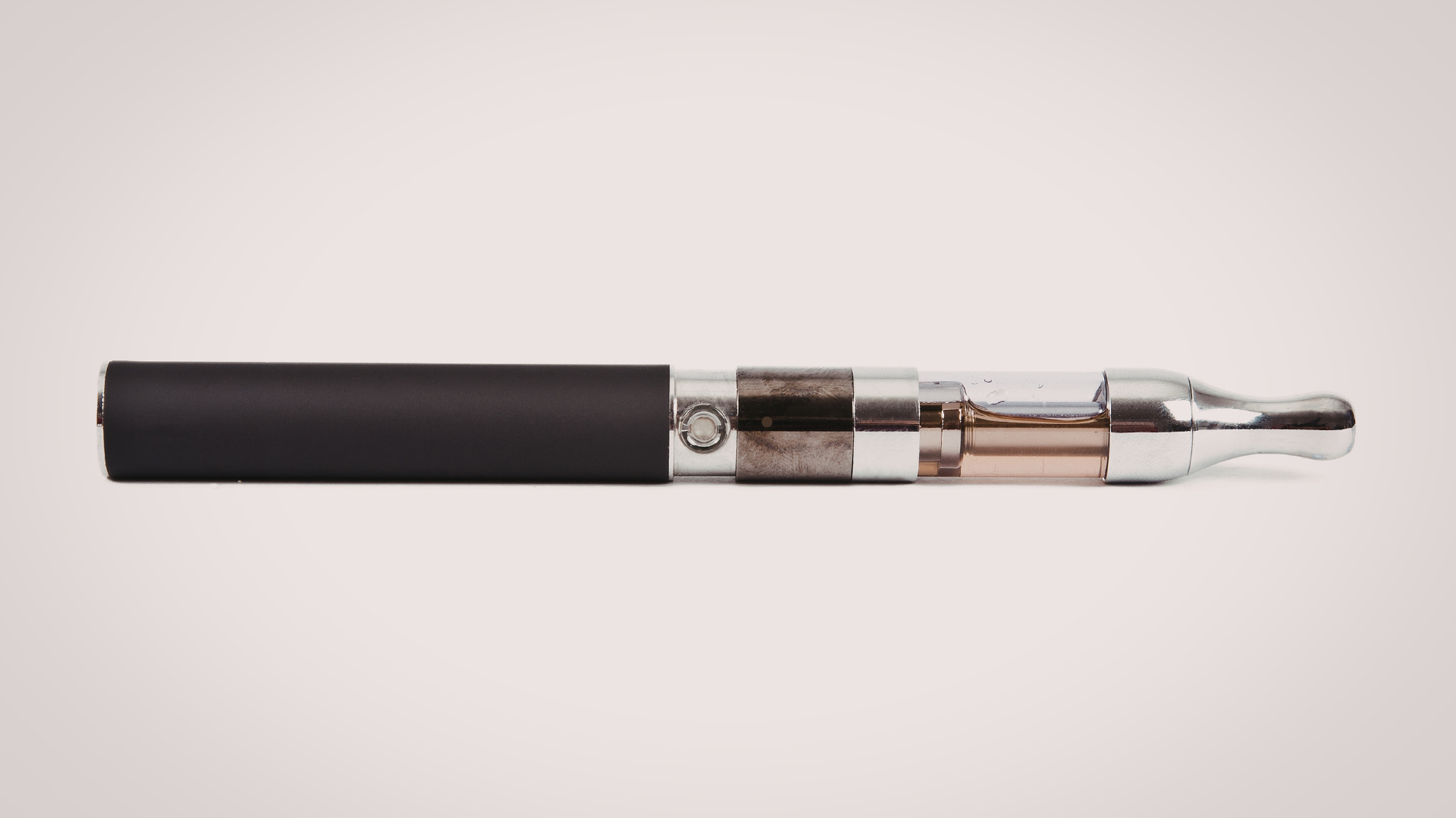 A close-up shot of a vape pen with a clear tank filled with e-liquid, showcasing a simple vaping dev