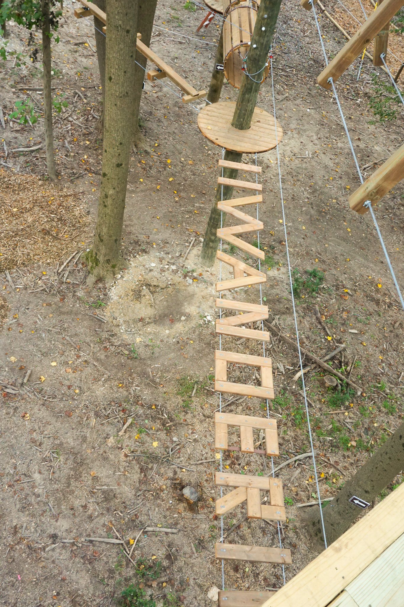 Wooden obstacle spelling Wander at Tree Trekkers high ropes course