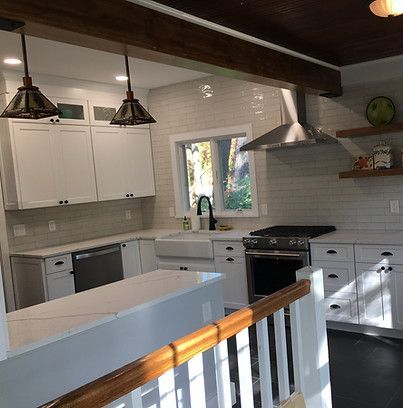 A kitchen with white cabinets , stainless steel appliances , a sink , and a stove.