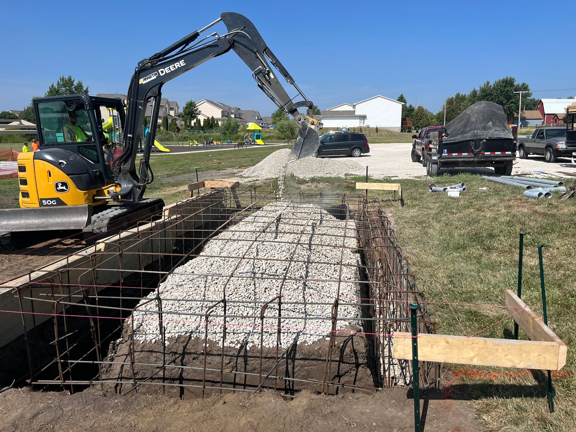 A construction site with a large excavator digging a hole in the ground.