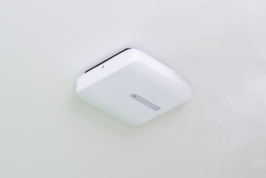 White rectangular device mounted on a white ceiling.