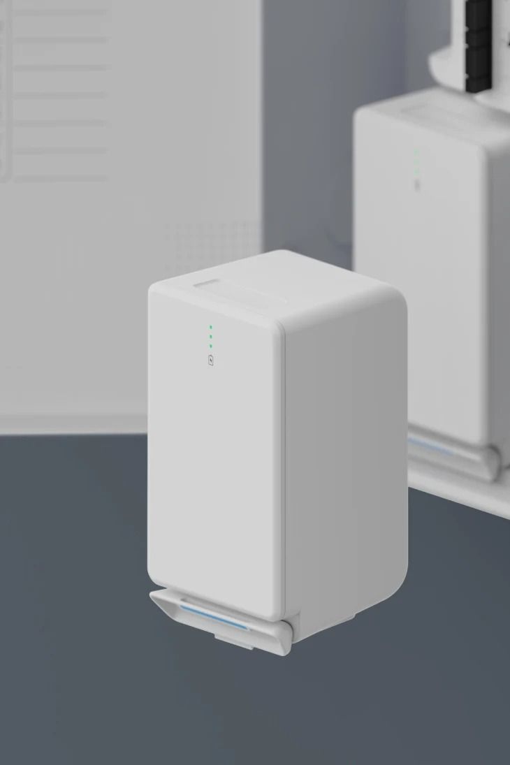 White cube-shaped device with small indicator lights, set against a blurred background.