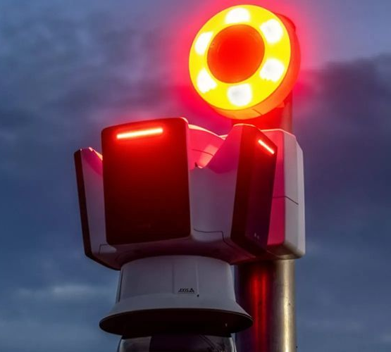 Red and white traffic light on a pole, with a glowing red circular light on top.