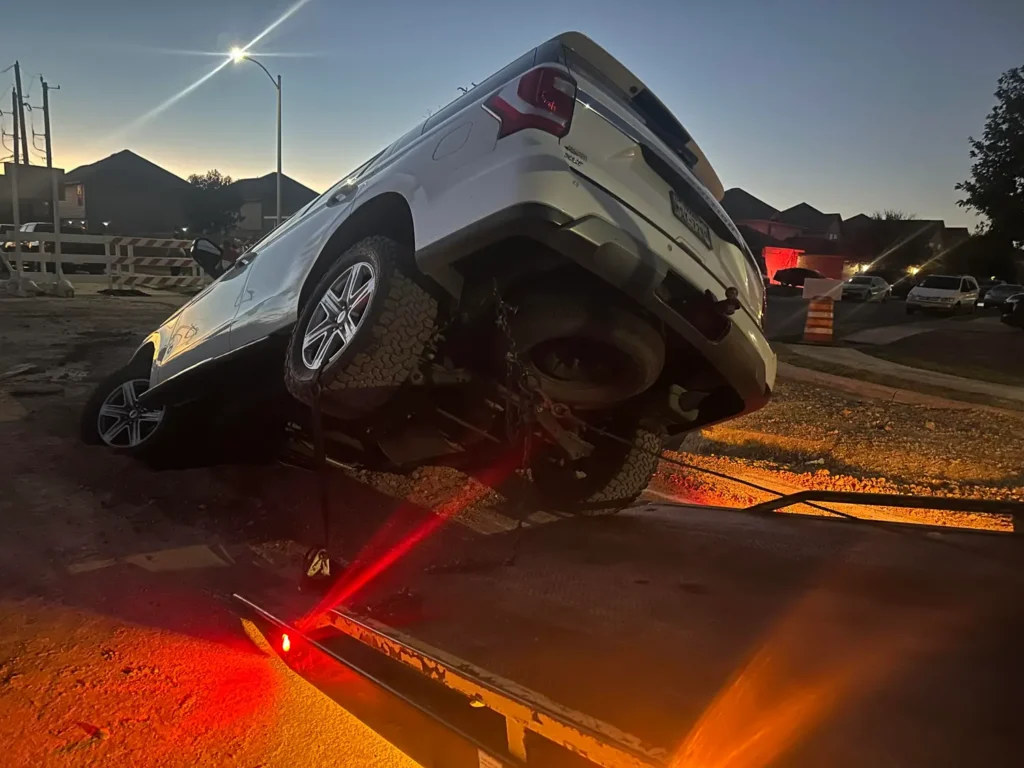 A car is on its side on a tow truck.