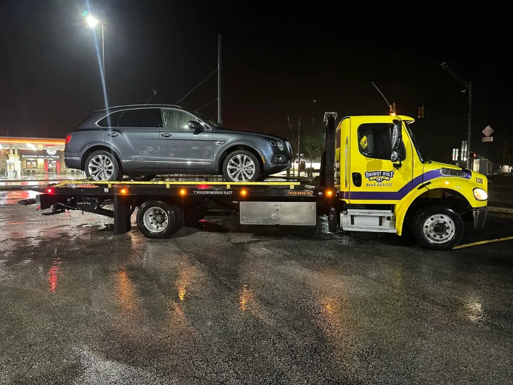 A tow truck is carrying a car on the back of it.