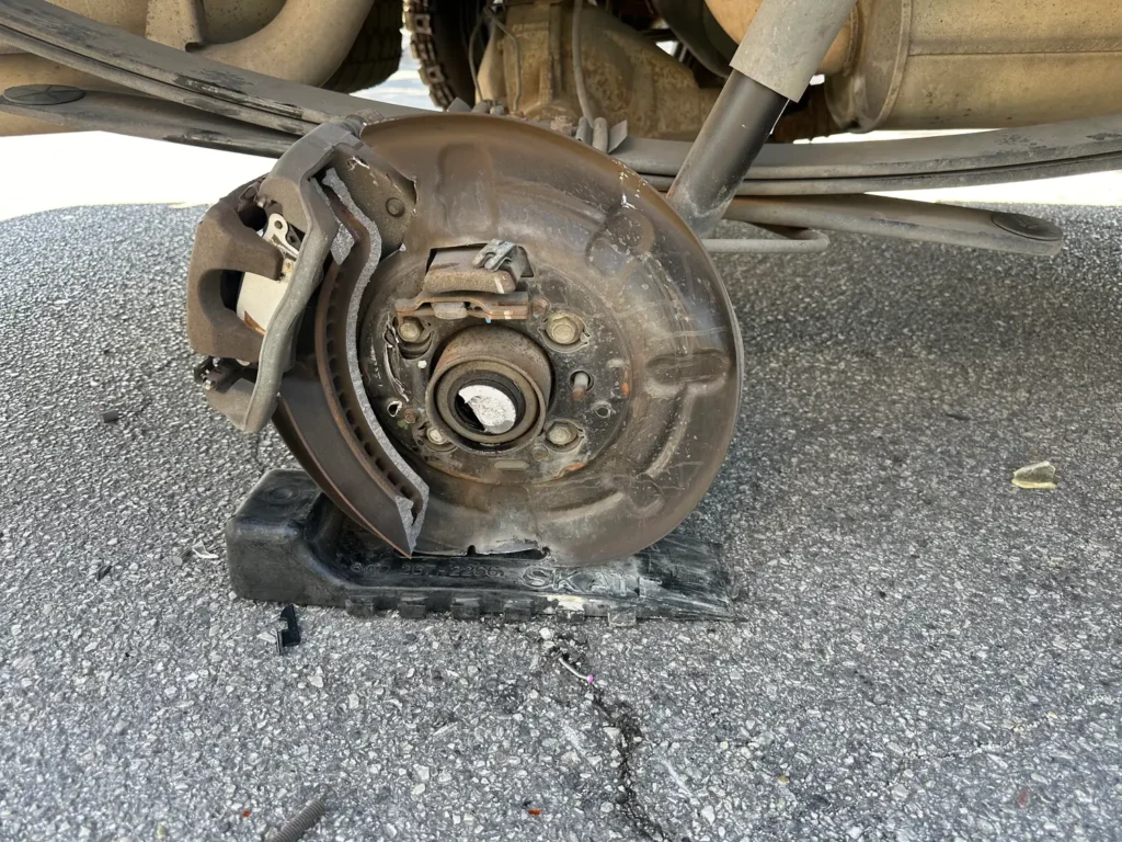 A car with a broken brake disc is sitting on the ground.