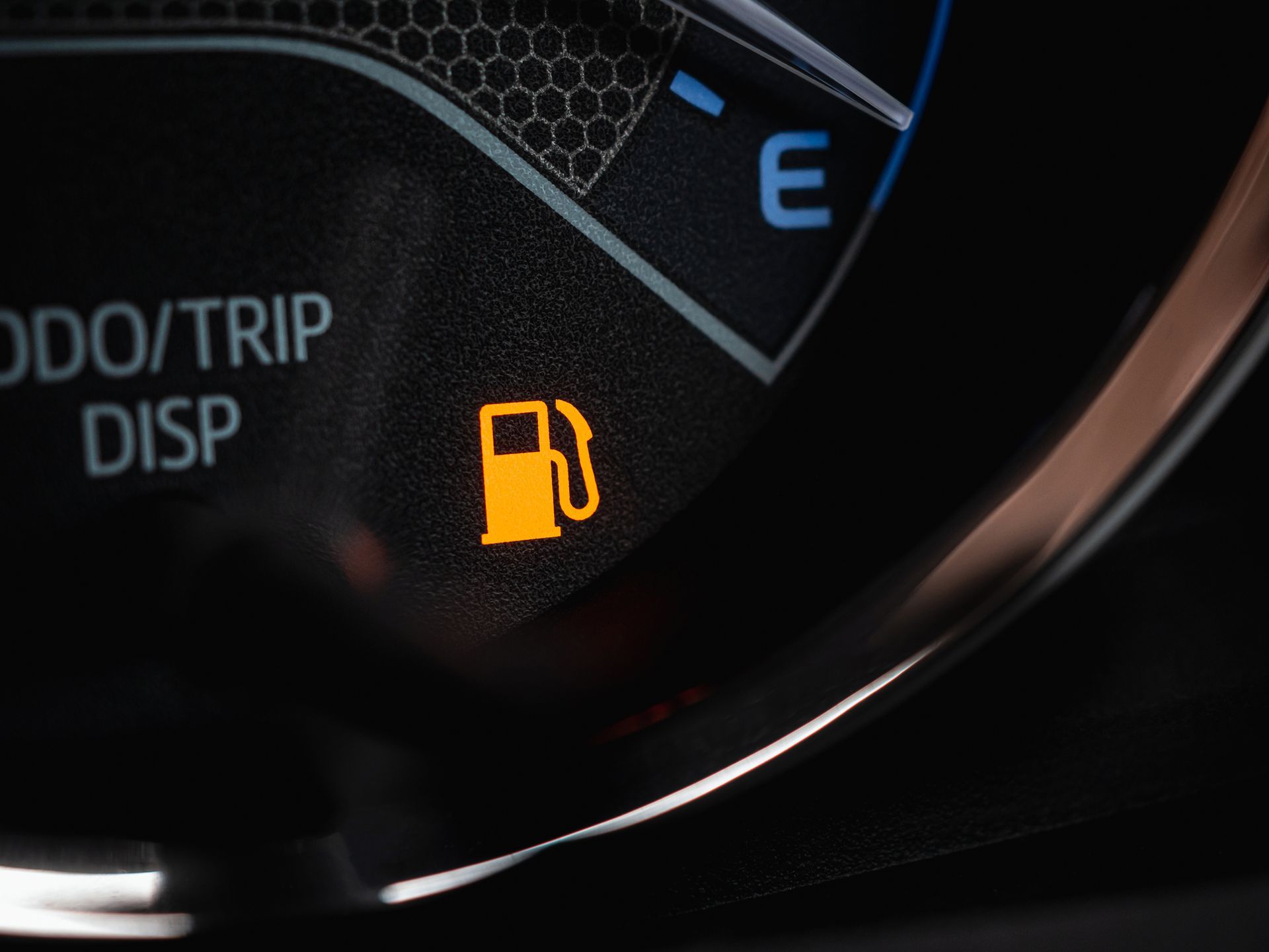 A close up of a car dashboard with a gas pump icon on it