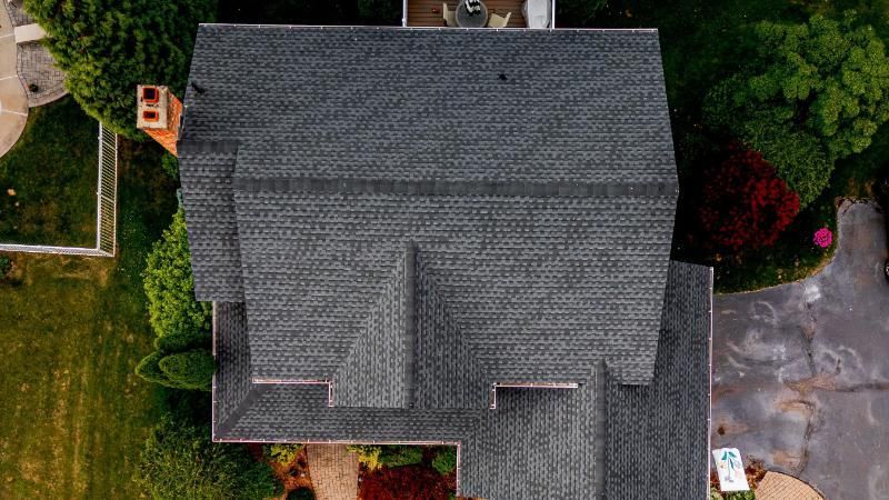 An aerial view of a house with a roof and a driveway.