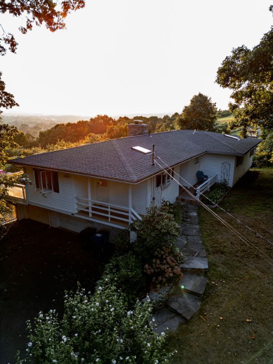 An aerial view of a house on a hill with stairs leading up to it.
