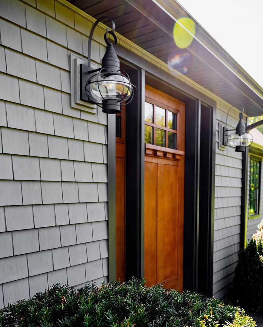 A house with a wooden door and a light on the side