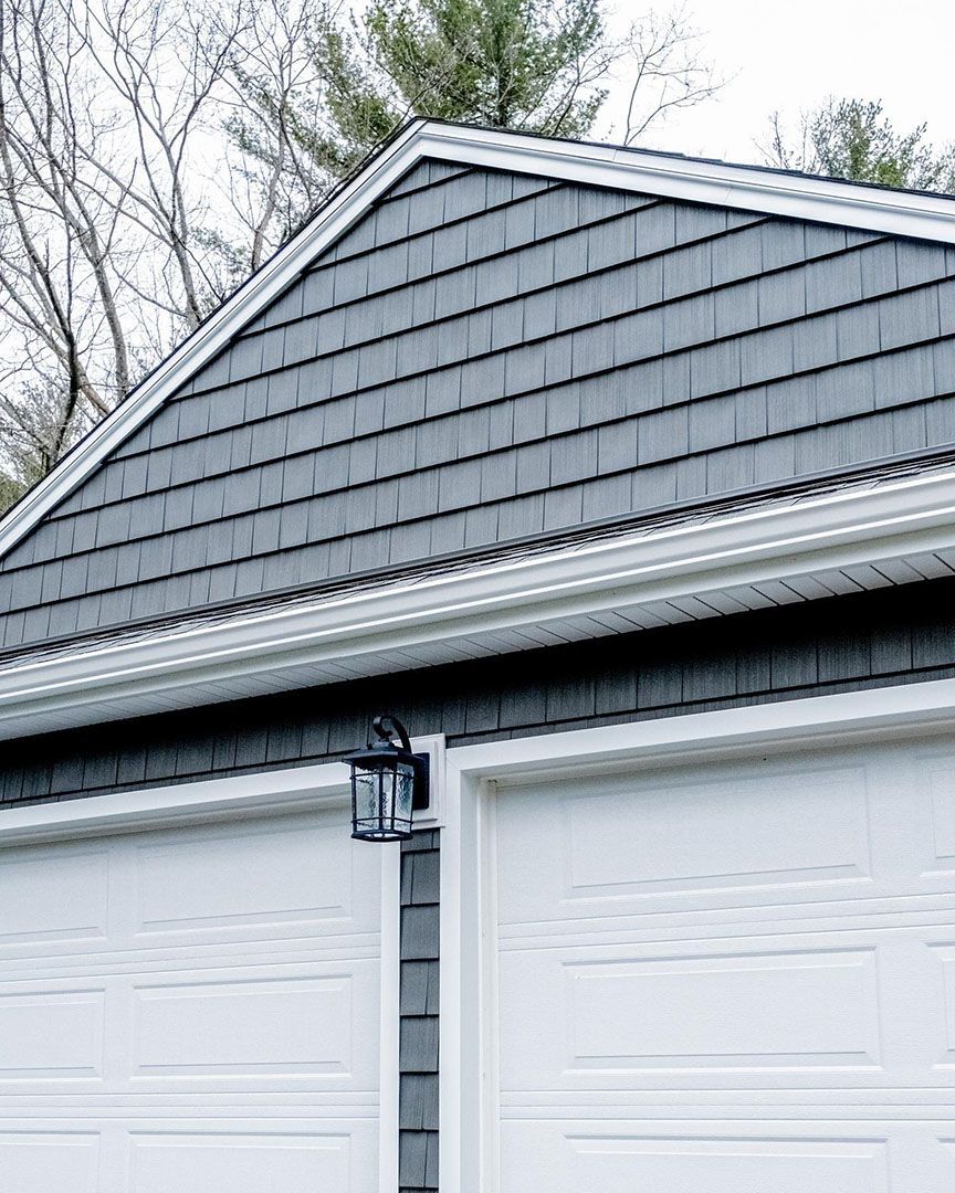 A garage with a gray roof and white garage doors.
