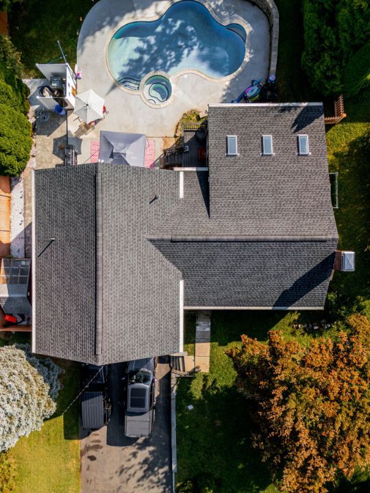 An aerial view of a house with a pool in the backyard.