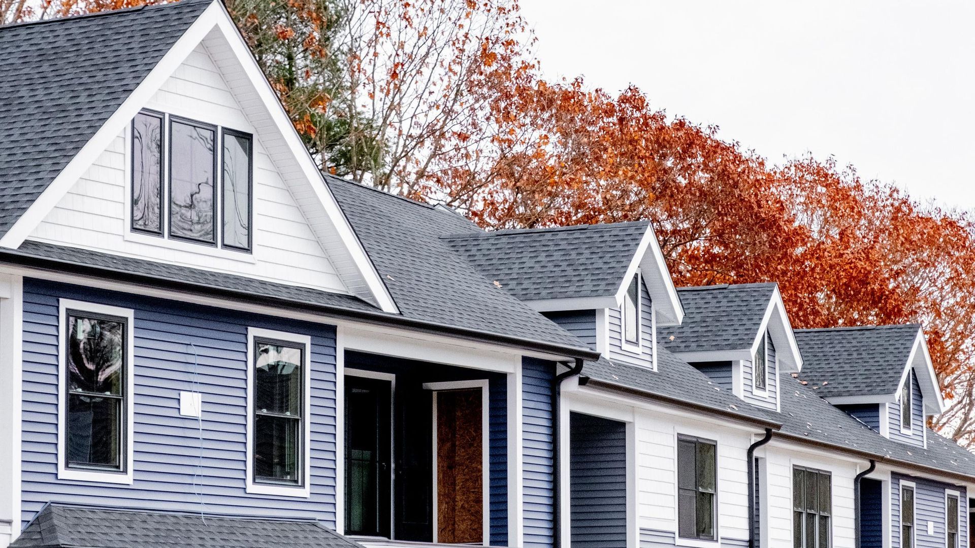 A row of blue and white houses with a gray roof.