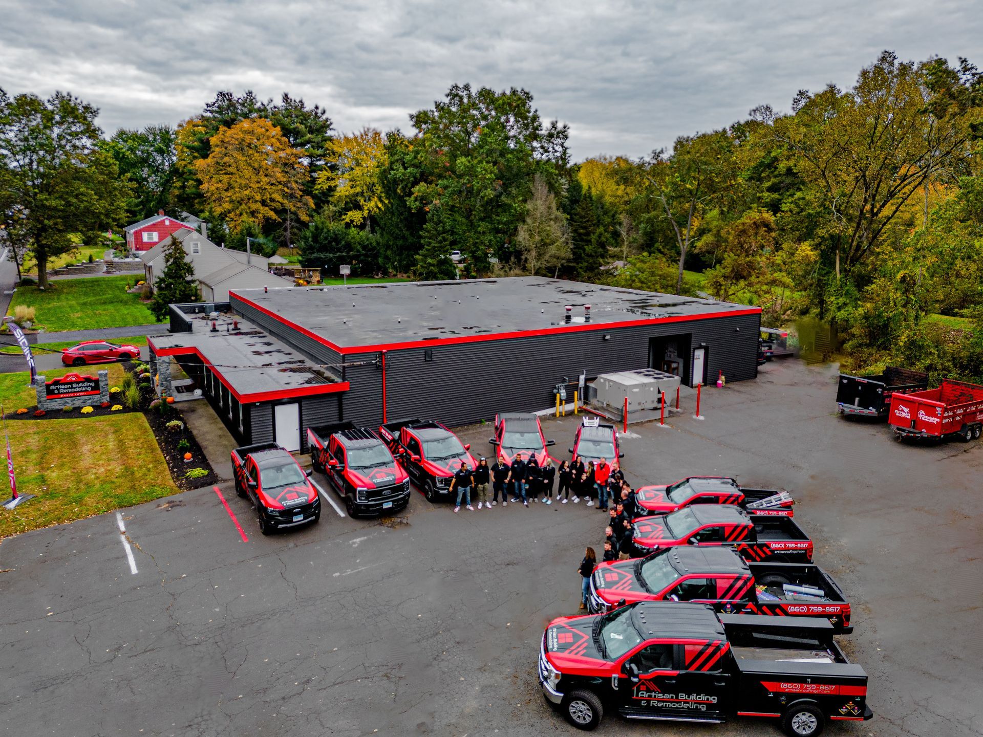 A group of red trucks are parked in front of a building.