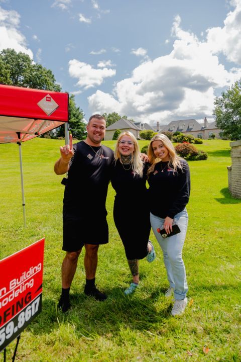 A group of people are posing for a picture in a grassy field.