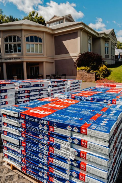 A stack of boxes sitting in front of a large house.