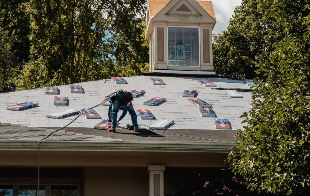 A man is working on the roof of a house.