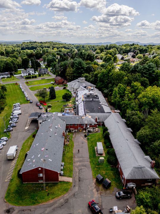 An aerial view of a large building with a lot of cars parked in front of it