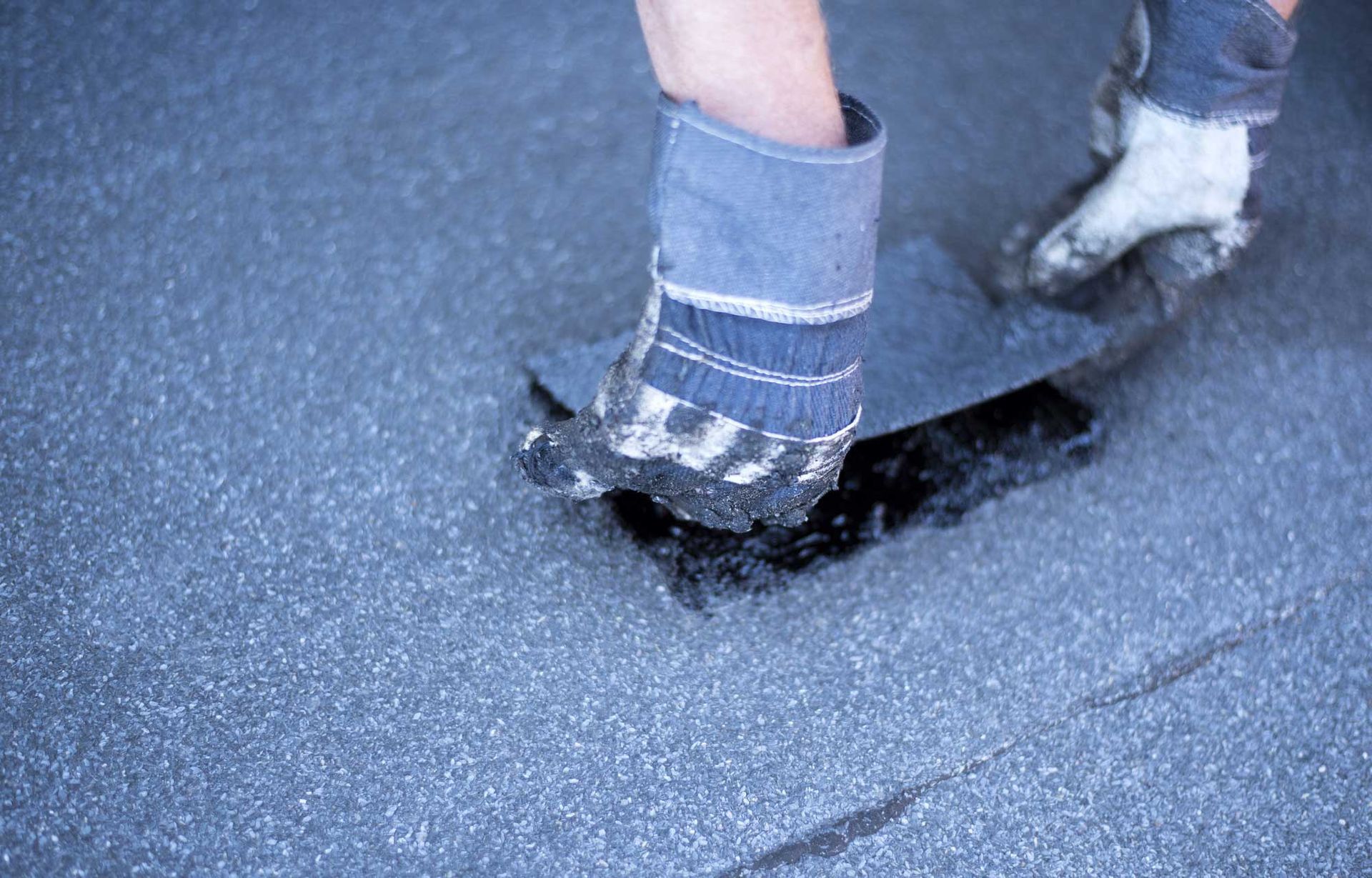 A person wearing socks and gloves is standing on a skateboard.