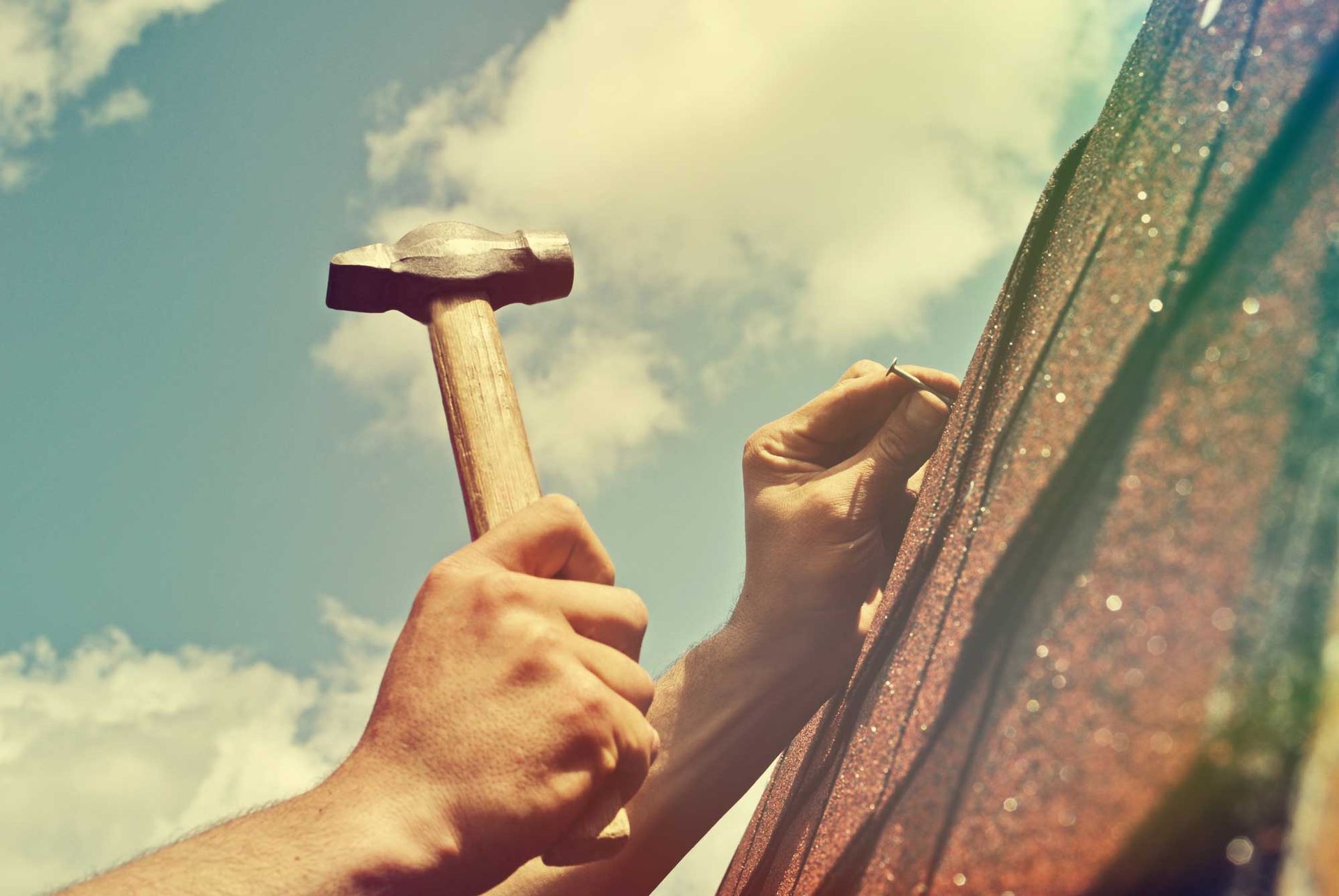 A person is hammering a nail into a wall.