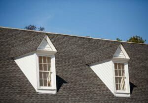 There are two windows on the roof of a house.