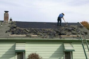 A man is working on the roof of a house.