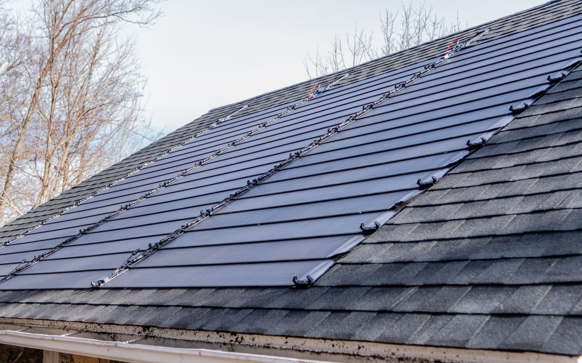 Solar panels installed on a residential roof, dark grey shingles.