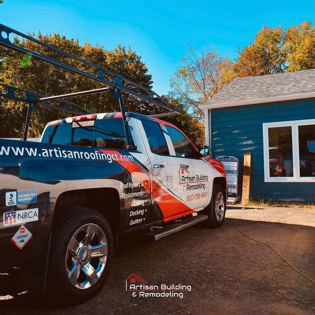 A truck is parked in front of a blue house.