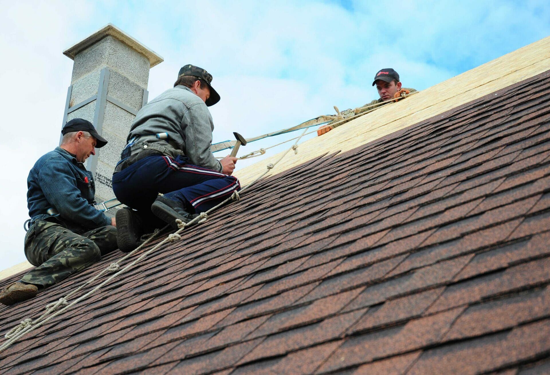 A group of men are working on a roof.