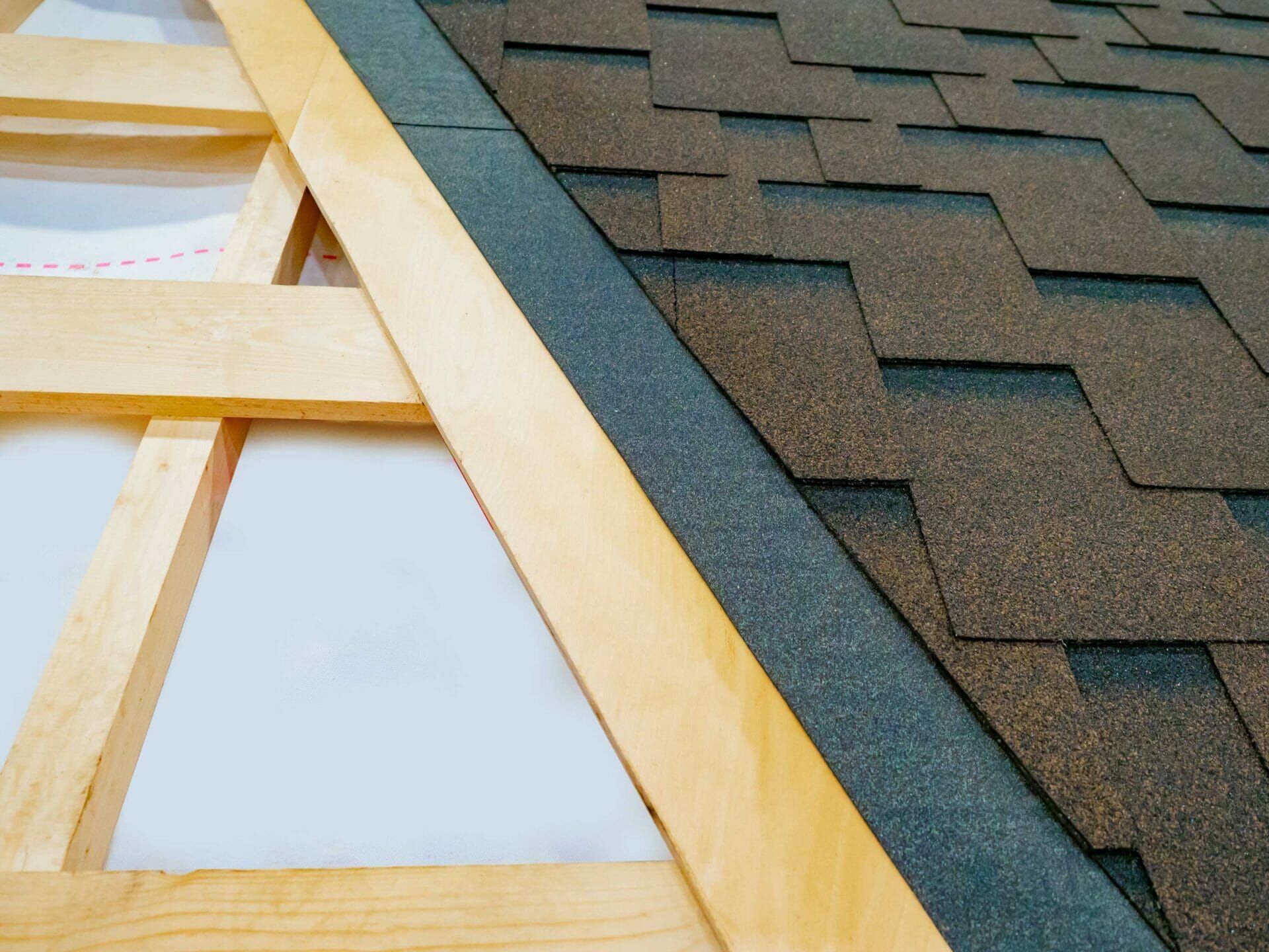 A close up of a roof with shingles and a wooden frame.