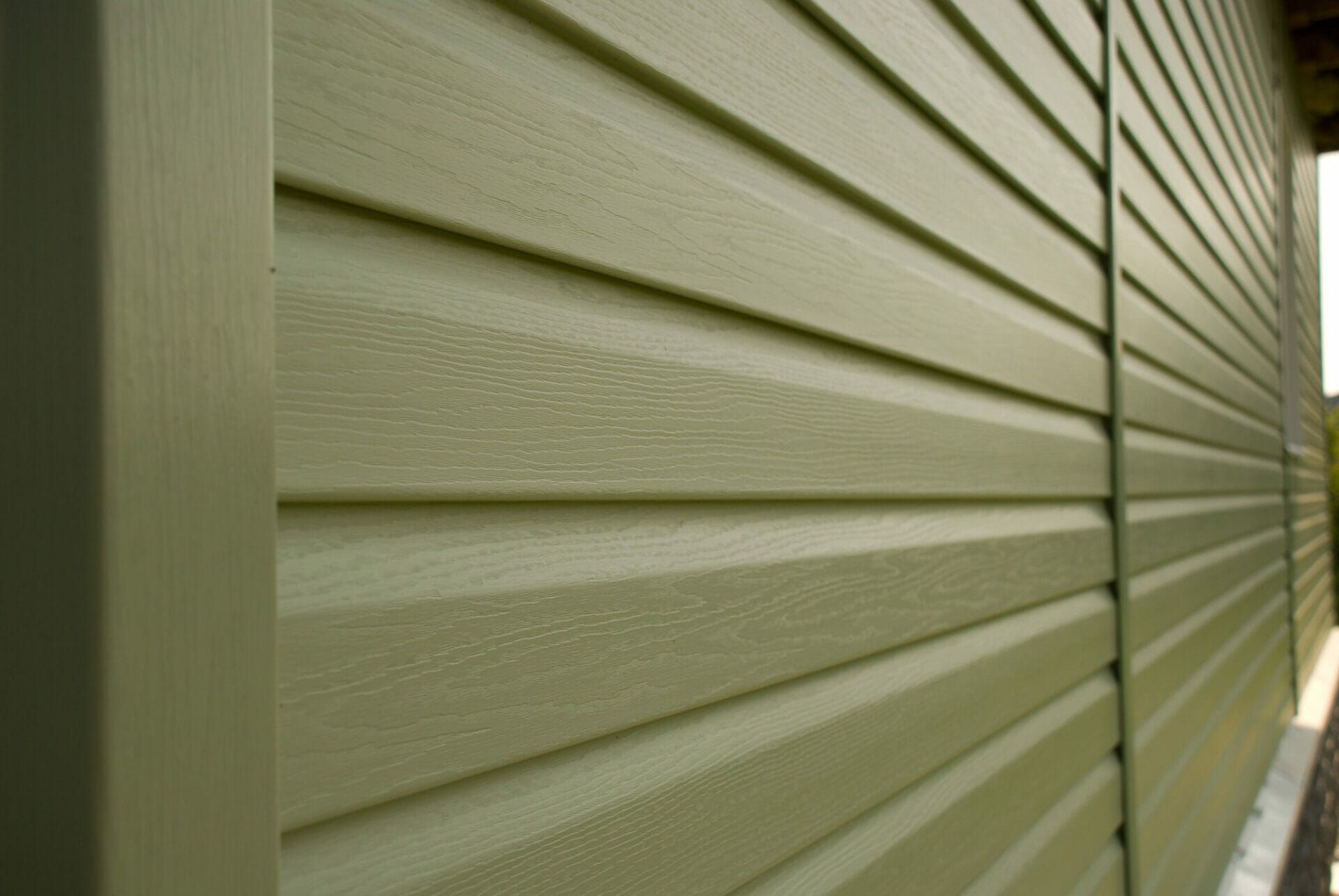 A close up of a green siding on a house.