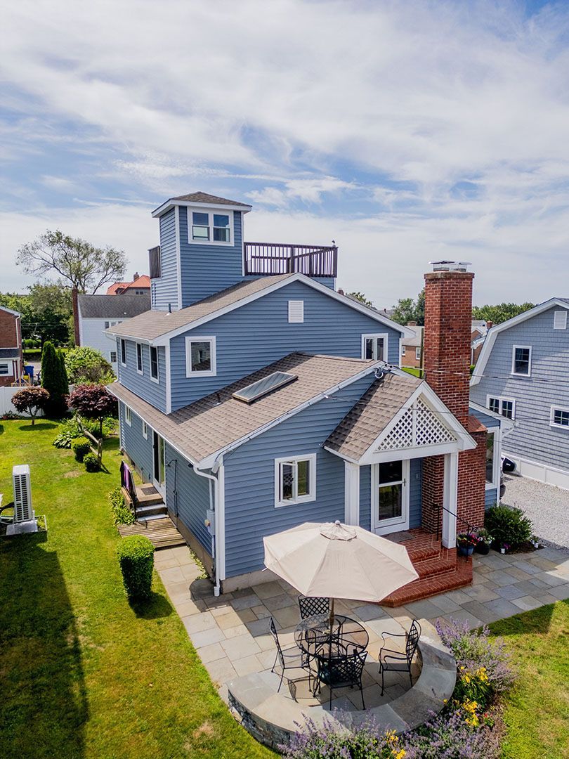 An aerial view of a large house with a blue siding