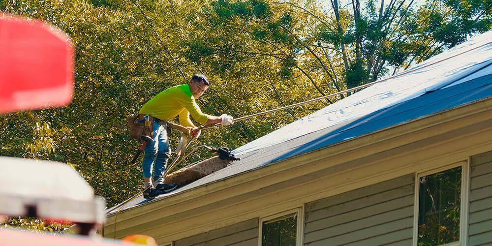 A man is working on the roof of a house.