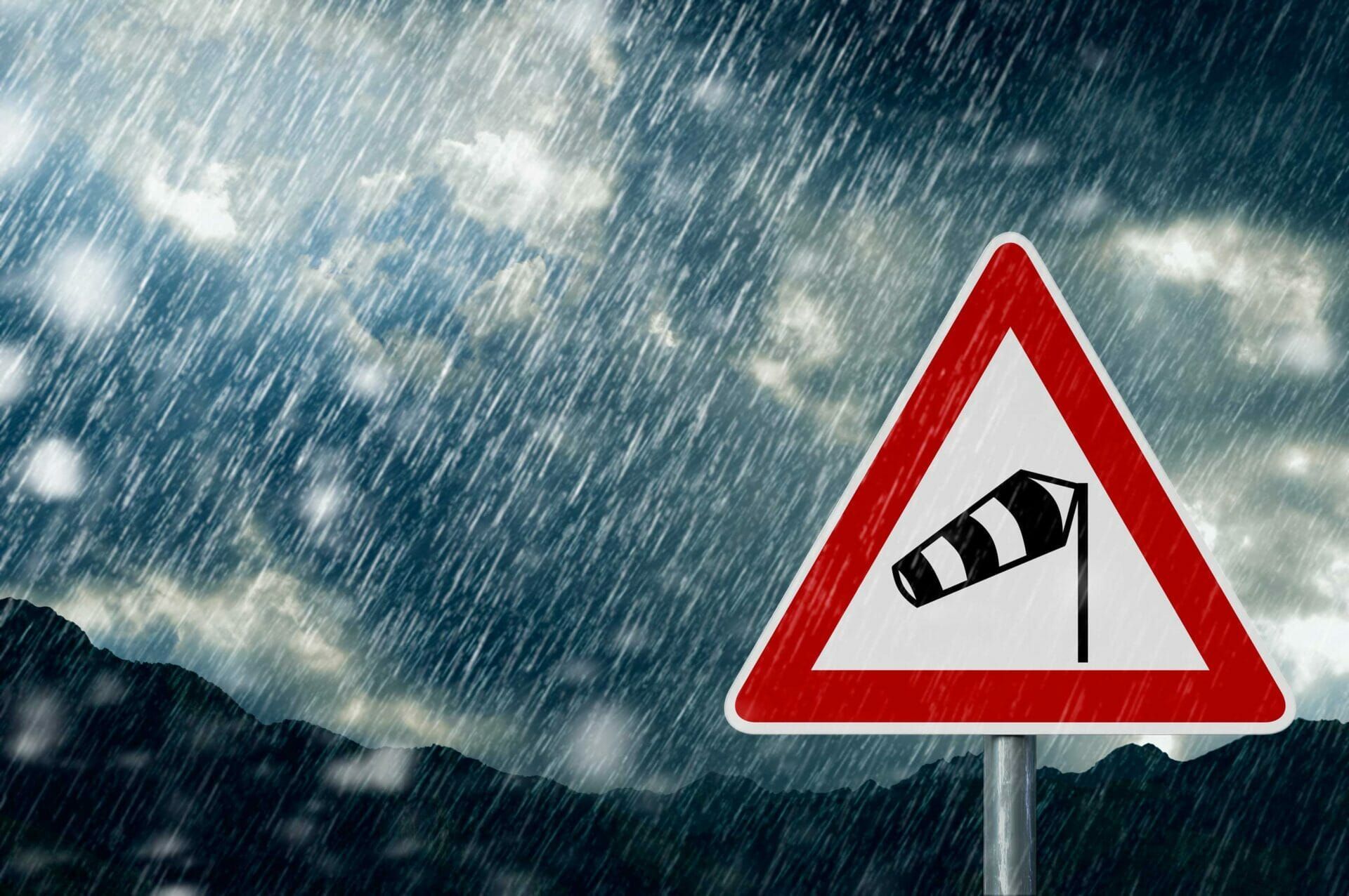 A red and white sign with a windmill on it in the rain