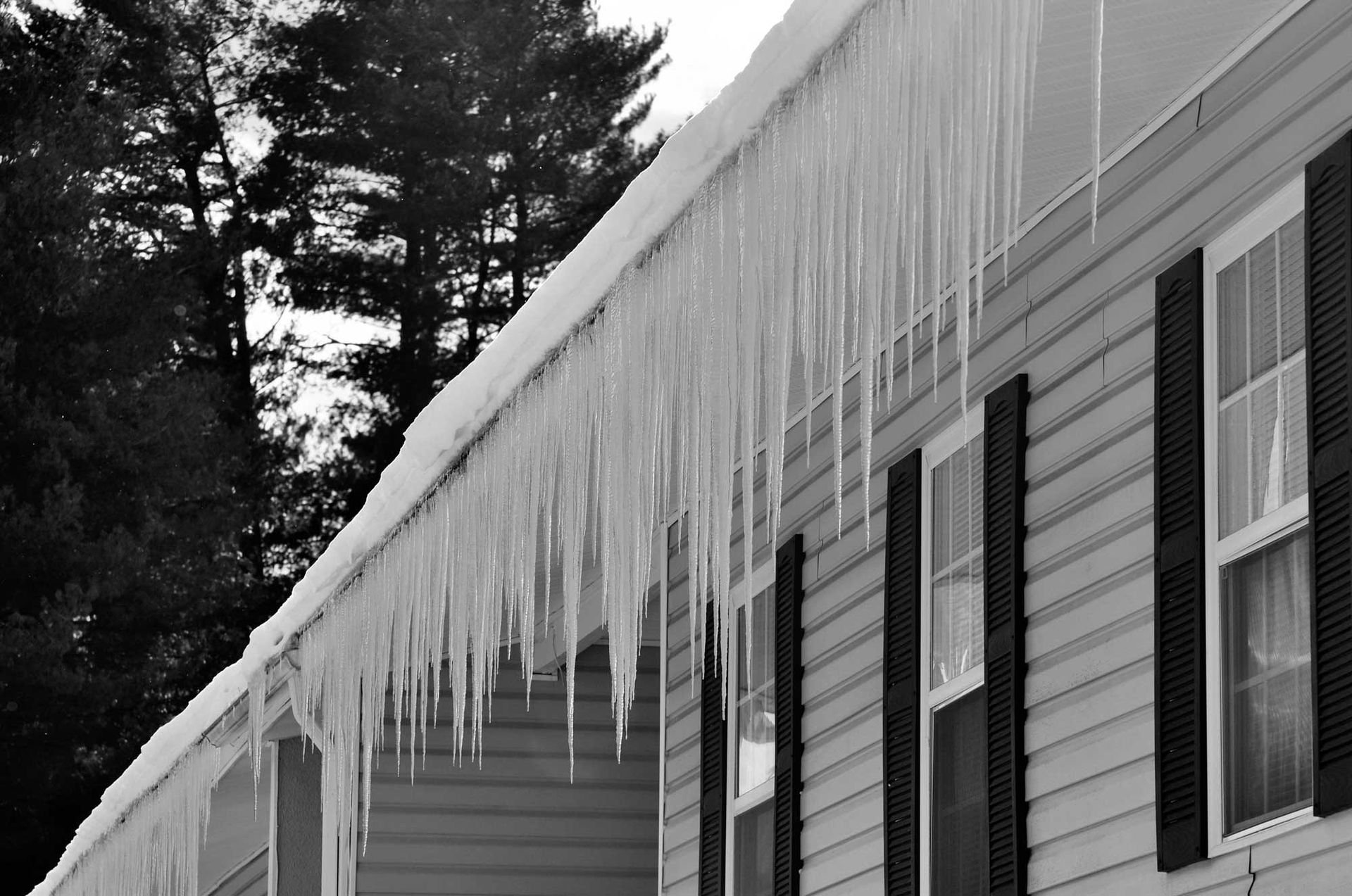 Icicles are hanging from the roof of a house