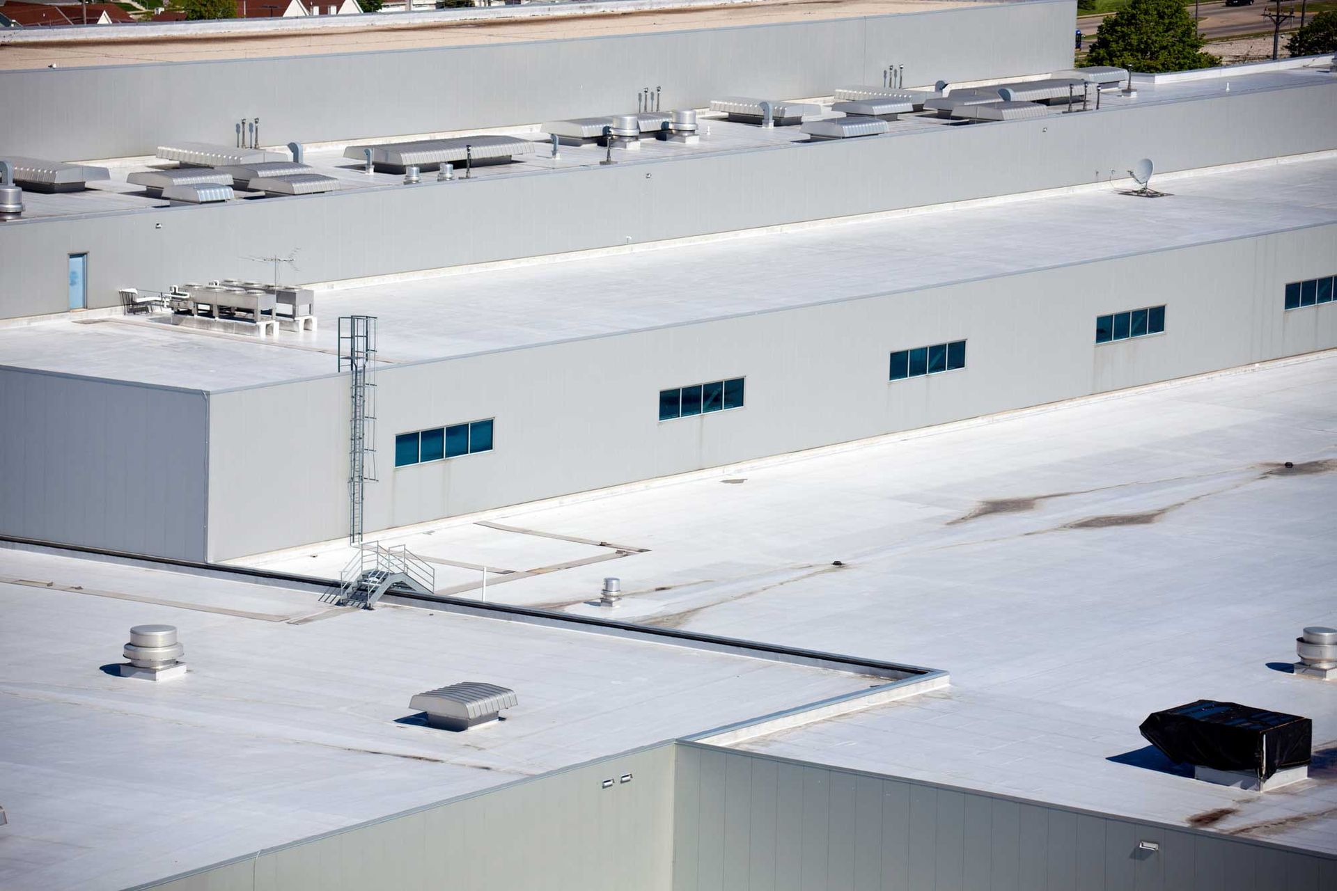 An aerial view of a large building with a white roof