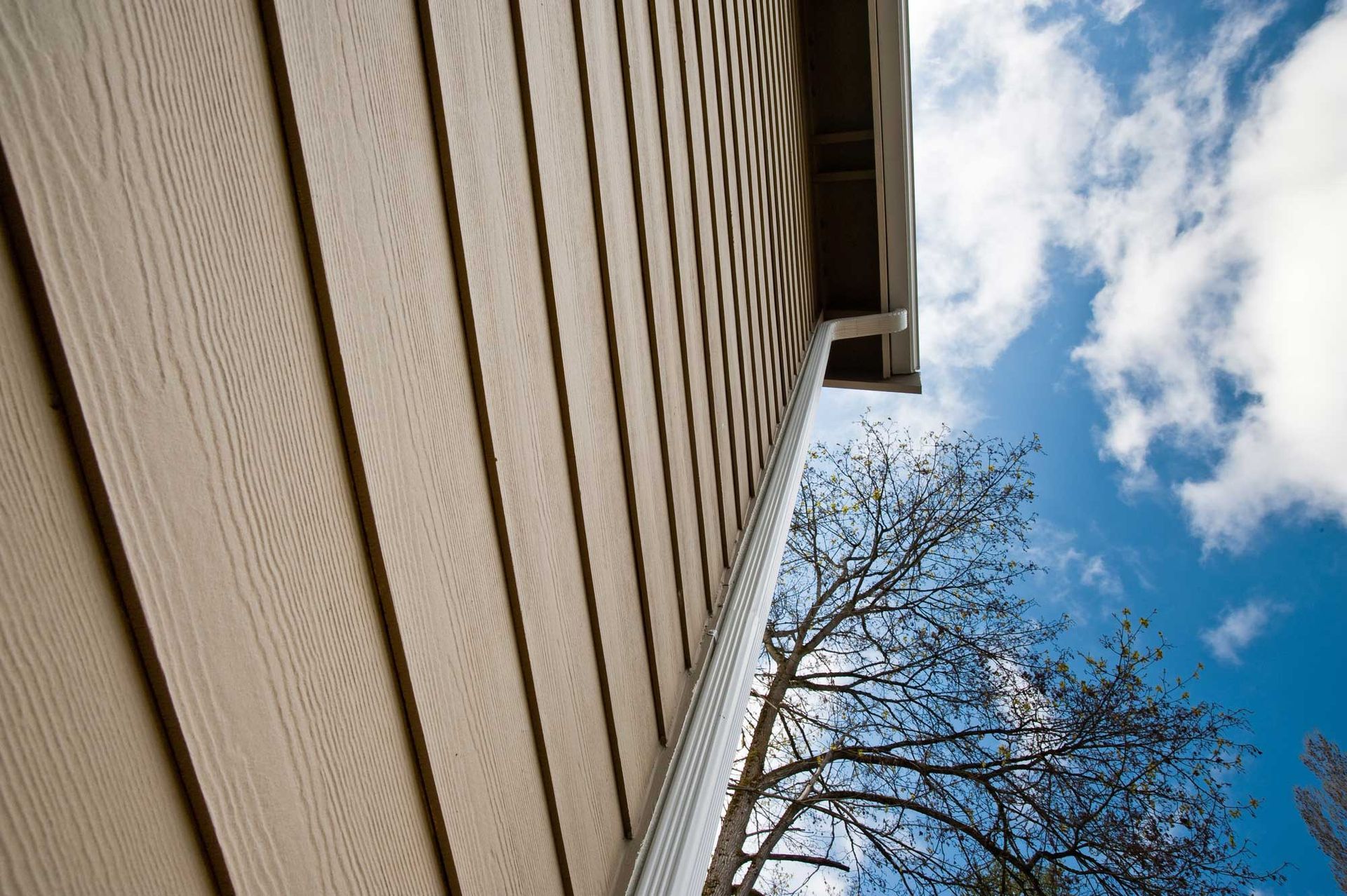 Looking up at the side of a house with a blue sky in the background.