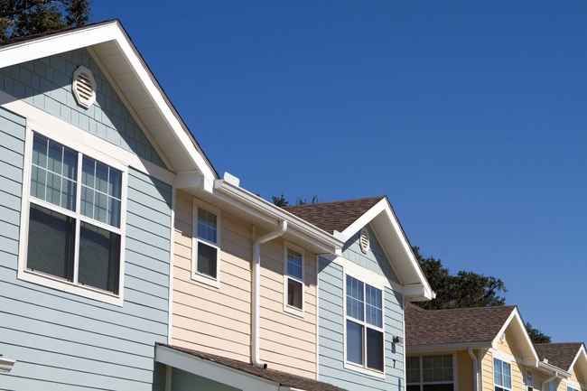 A row of houses with a blue sky in the background