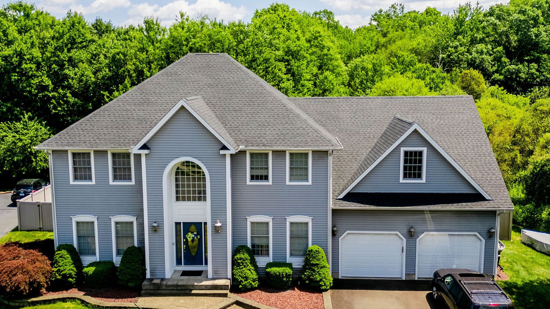 An aerial view of a large house with a car parked in front of it.