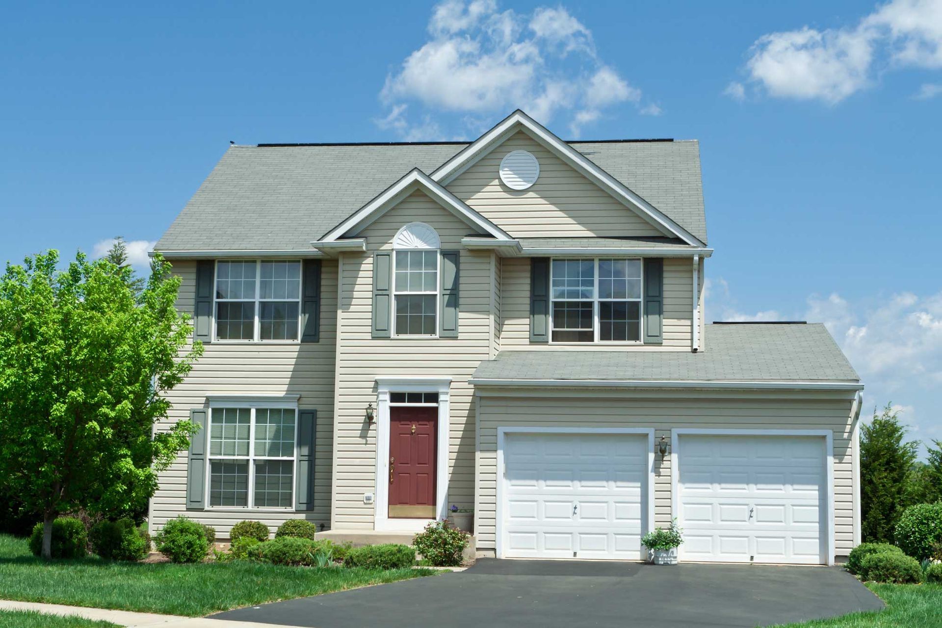 A house with two garage doors and a red door