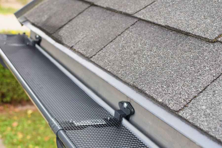 A close up of a gutter on the roof of a house.