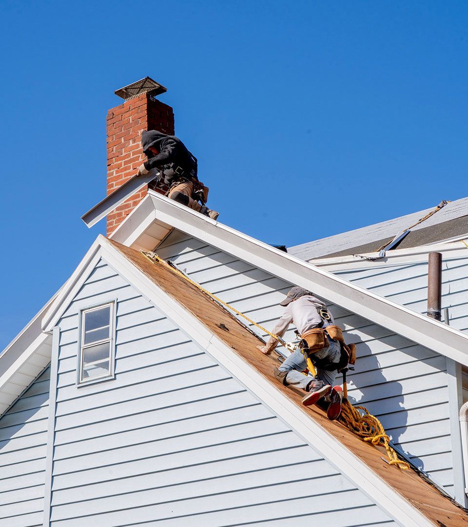 A man is working on the roof of a house.