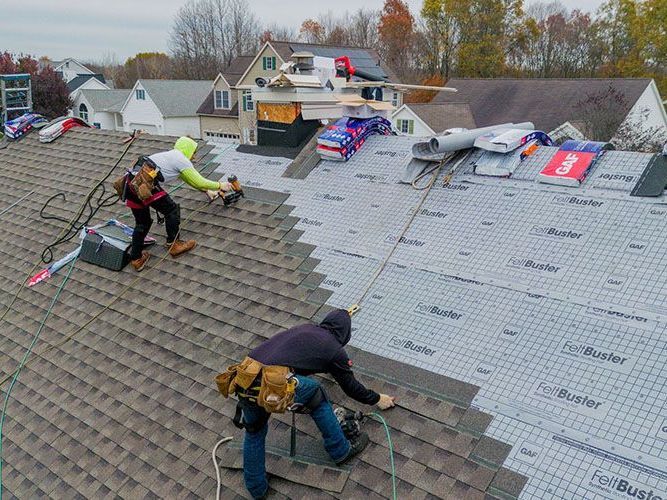 A group of men are working on a roof.