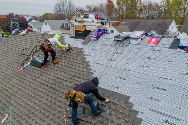 A group of men are working on a roof.